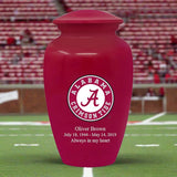 A red University of Alabama cremation urn with a white 'Alabama Crimson Tide' logo and an engraving example on the front.
