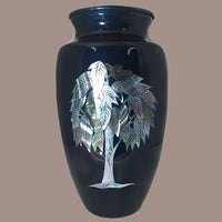 a themed mother of pearl with a tree of life image on a cremation urn